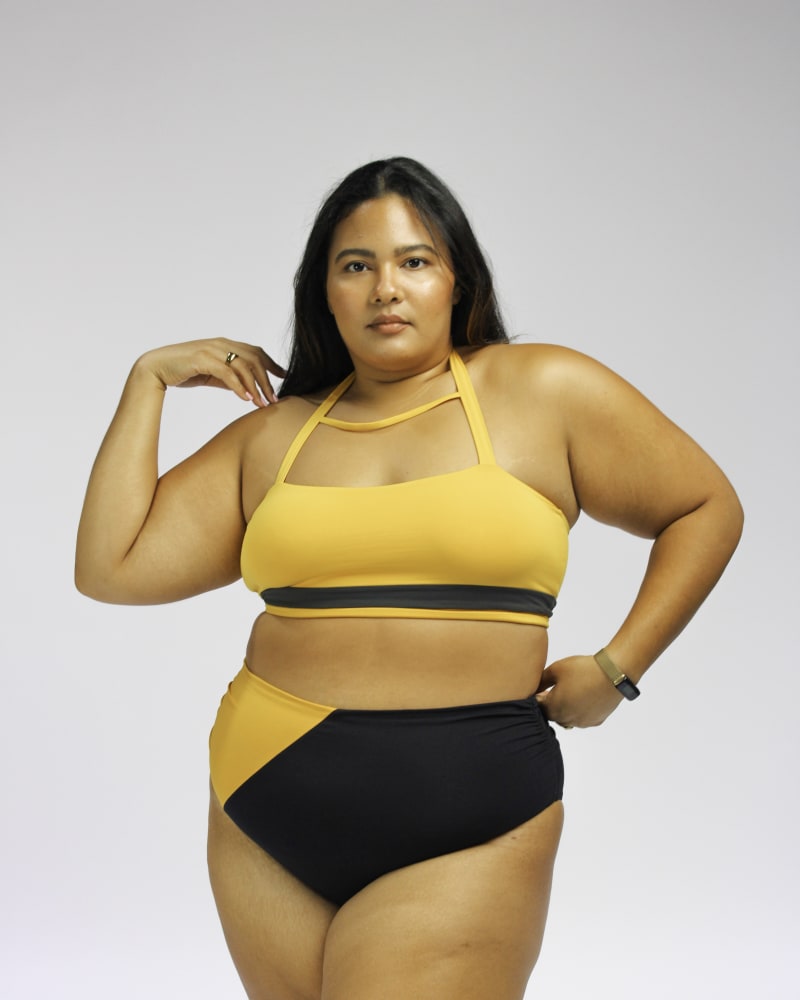 Front of a model wearing a size XL Moe vintage inspired halter bikini top in Mustard Yellow and Dark Grey by Mary Mercedes Swim. | dia_product_style_image_id:352232